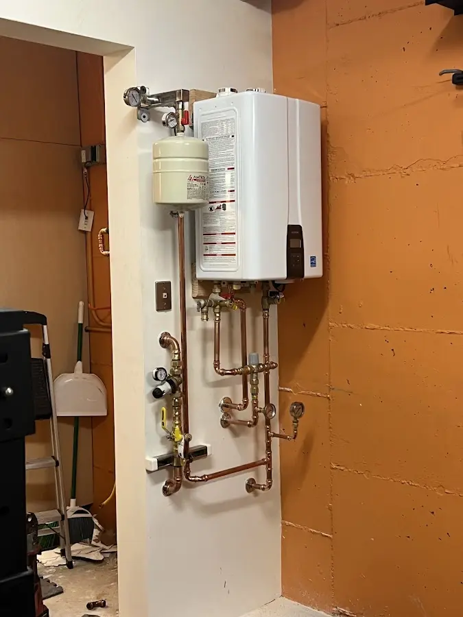 Plumbing technician inspecting water heater connections in Hayfork
